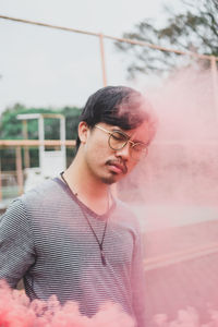 Man with closed eyes standing amidst powder paint outdoors