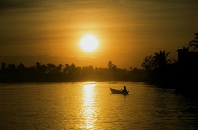 Silhouette people on boat against sky during sunset
