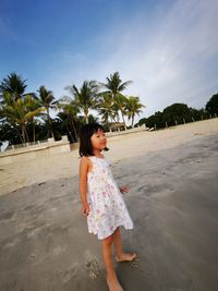 Full length of young woman standing on beach