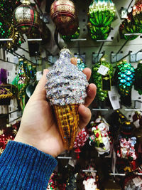 Midsection of person holding ice cream at market