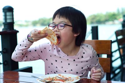 Girl eating pizza in restaurant