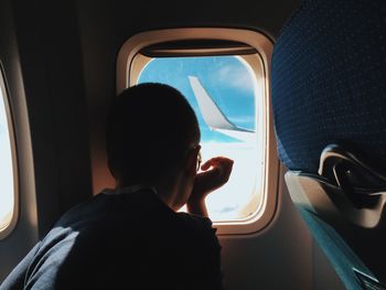 Rear view of child sitting in airplane