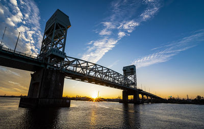 Low angle view of bridge over river against sky