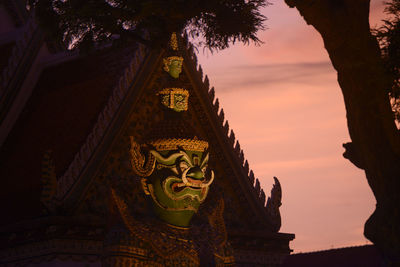 Statue of demon at wat arun temple during sunset