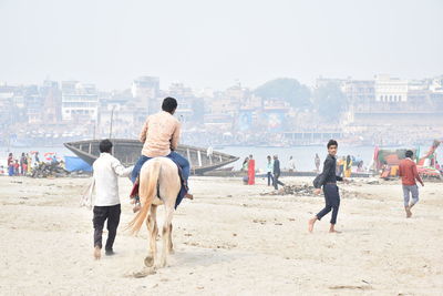 Rear view of people on beach in city