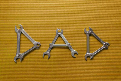 Directly above shot of metal chain against yellow background