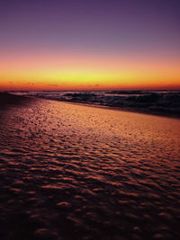 Scenic view of sea against dramatic sky during sunset