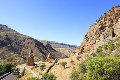 Panoramic view of building and mountains against clear sky