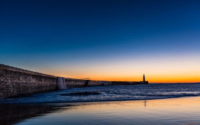 Scenic view of sea against clear sky during sunset