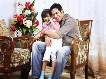 Portrait of smiling young couple sitting on table