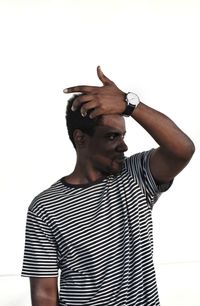 Portrait of young man standing against white background