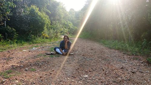 People sitting on street amidst trees in forest