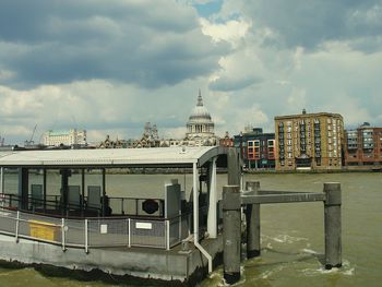 Built structure on thames river against st pauls cathedral