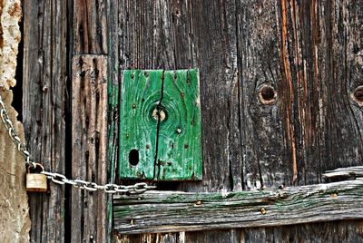 Close-up of rusty padlock on wooden door