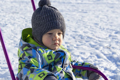 A small child sledding in the winter on white snow, outdoors.