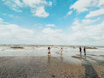 People on beach against sky