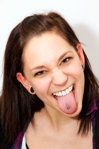 Portrait of young woman with piercing on tongue