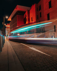 Light trails of tram on road at night