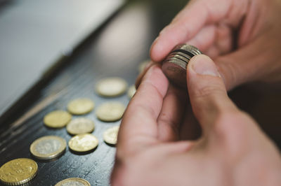 Business man counting money. rich male hands holds and count coins of different euros on table