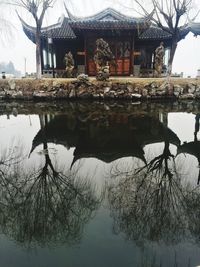 Reflection of trees and buildings on lake