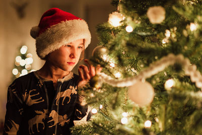 Portrait of boy standing against christmas tree