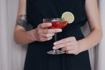 Midsection of woman drinking glass