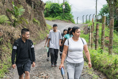 Group of people hiking high up in the colombian mountains. family out for a walk on a dirt trail