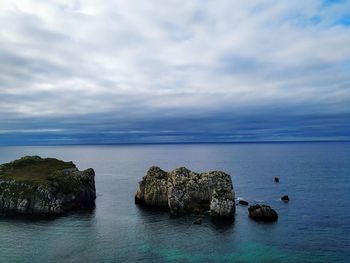 Rocks in sea against sky