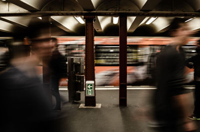 Blurred motion of people walking by train at subway station