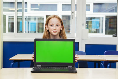 Portrait of smiling girl sitting on table
