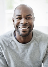 Portrait of happy man sitting at home