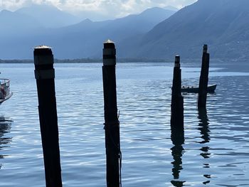 Wooden posts in lake against mountains