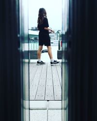 Rear view of woman standing by window in building