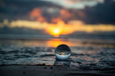 Close-up of water on beach during sunset