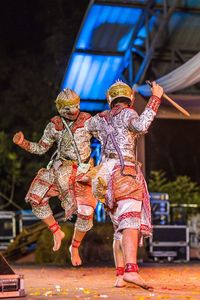 Full length of men in traditional costumes performing at night