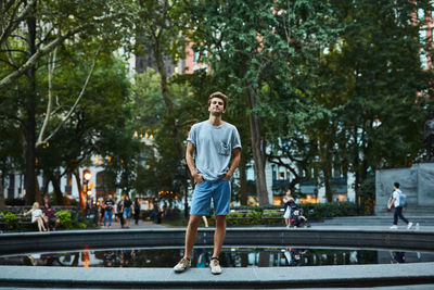 Young man standing on road in city