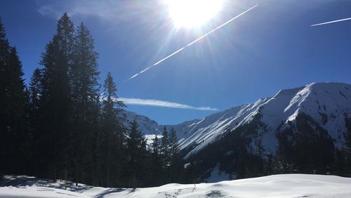 Scenic view of snowcapped mountains against sky on sunny day