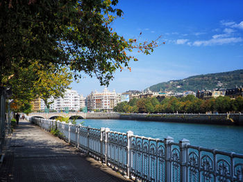 Bridge over river in city against sky