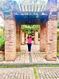 Woman standing against brick wall