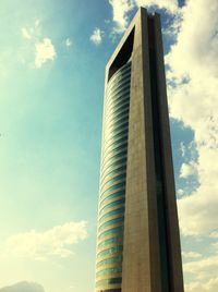 Low angle view of modern building against cloudy sky