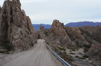 Road amidst mountains against clear sky