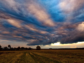 Scenic view of agricultural field against dramatic sky