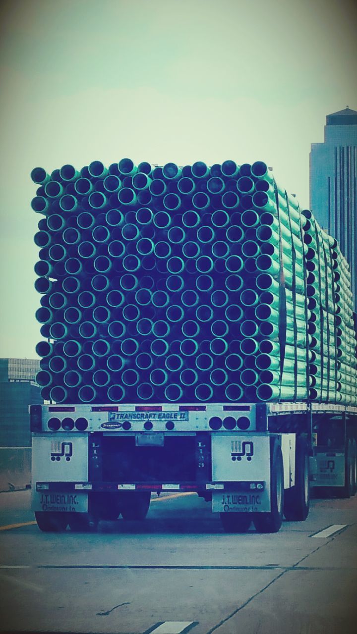 STACK OF PIPES IN CITY AGAINST SKY