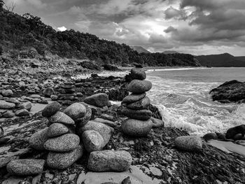 Stones on beach against sky