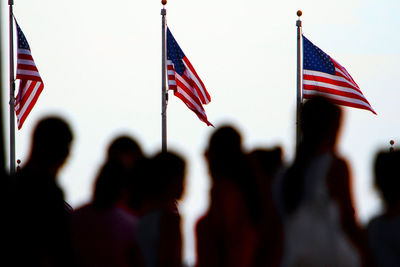 Silhouette people against american flags