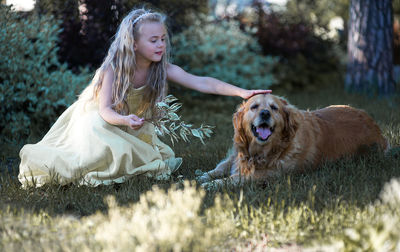 Girl with dog sitting on grass