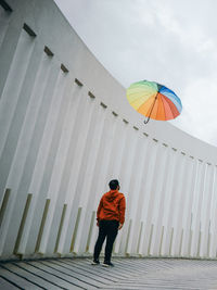 Rear view of man with an umbrella against white architecture