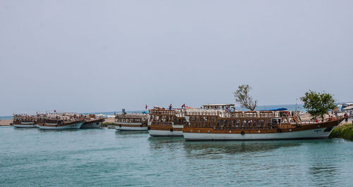 Boats in sea against clear sky