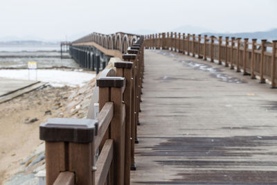 Wooden posts on beach against clear sky