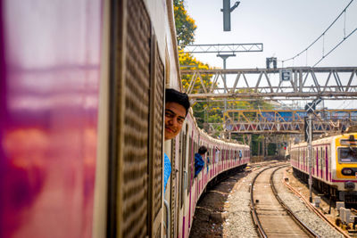 Portrait of man peeking from train door in city